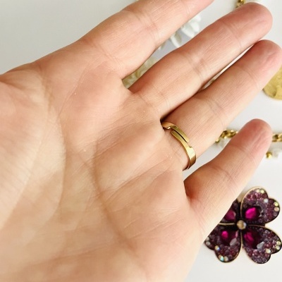 Mão com anel dourado e acessórios de joalharia ao fundo