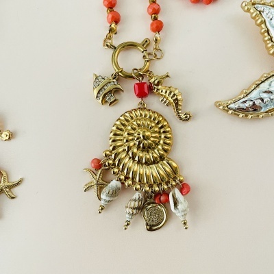 Colar dourado com concha em espiral e pendentes de pérolas, contas coral e figuras marinhas