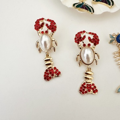 Brincos lagosta dourados com pedras vermelhas e pérola