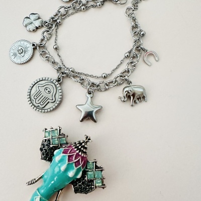 Pulseira prateada com pendentes diversos e pendente colorido abstrato
