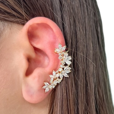 Ear cuff dourado com pedras brilhantes em forma de folha