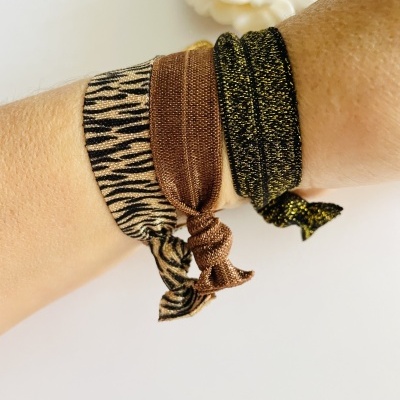 Pulseiras elásticas coloridas em tecido com padrões diversos no pulso