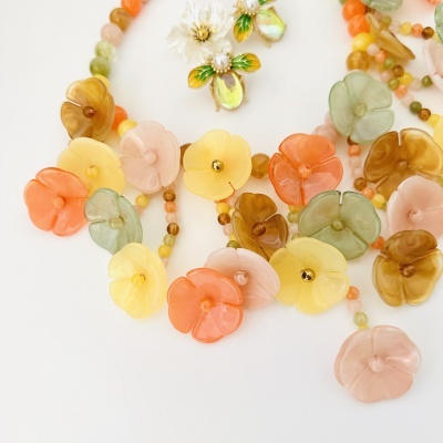 Colar colorido com flores em plástico translúcido e presilhas decorativas de abelha
