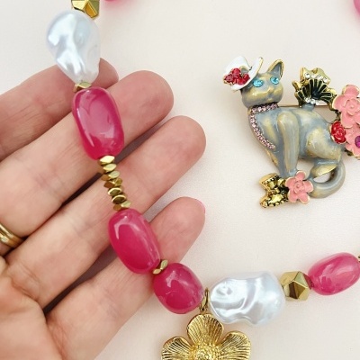 Colar com contas cor-de-rosa, pendente flor dourada e broche gato cinzento decorado