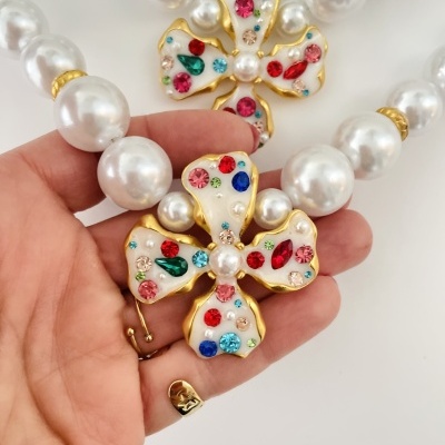 Colar de pérolas com flor dourada decorada com pedras coloridas