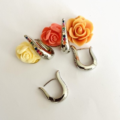 brincos prateados curvados com pedras coloridas e flores decorativas de resina