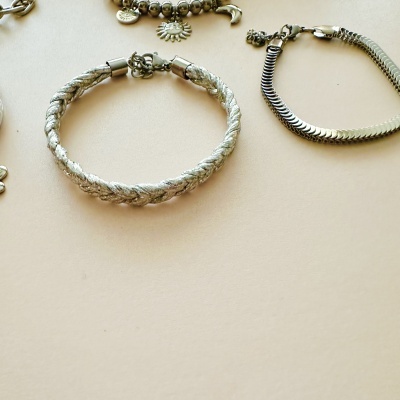 Pulseiras prateadas com diferentes texturas e pendentes
