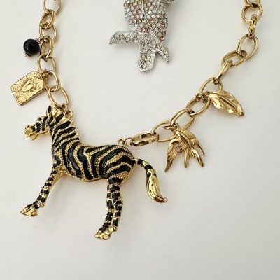 Colar dourado com pendente de zebra e outros pendentes variados
