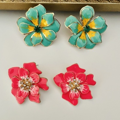 Quatro brincos em forma de flor azul com amarelo e vermelho com cristais