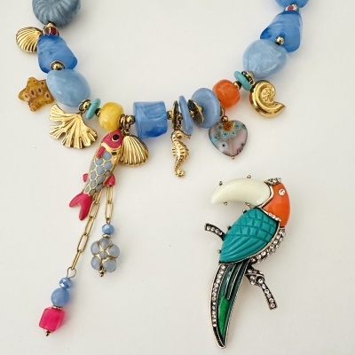 Colar azul com pendentes dourados e broche tucano colorido