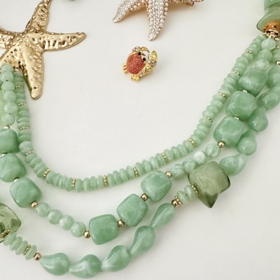 Colar verde com pendentes de estrela-do-mar e caranguejo dourado
