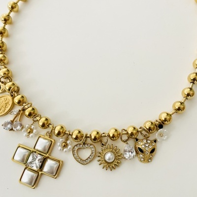 Colar dourado com pendentes variados e flores brancas