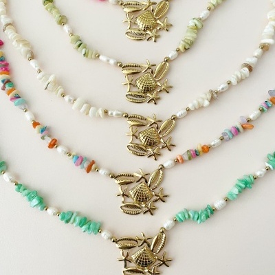 Colares com pedras coloridas, pérolas e pendentes dourados com motivos marinhos