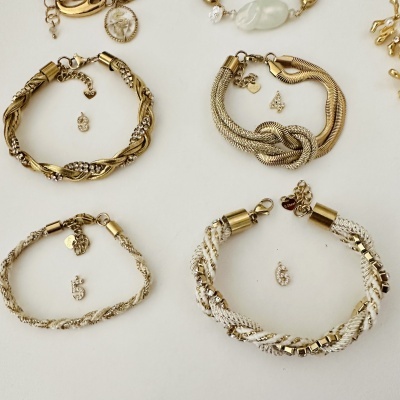 Pulseiras douradas e prateadas entrelaçadas com números 3, 4, 5, 6