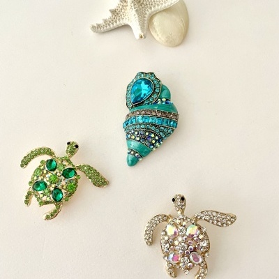 Bijutaria de tartarugas, concha azul e estrelas do mar sobre fundo branco