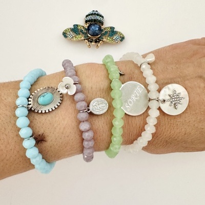 Pulseiras coloridas com pedras e pendentes prateados e broche abelha com pedras coloridas