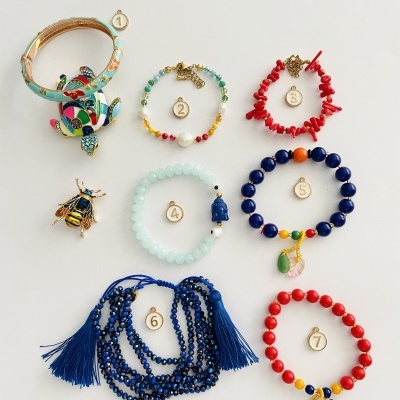 Conjunto de oito pulseiras coloridas numeradas sobre fundo branco.