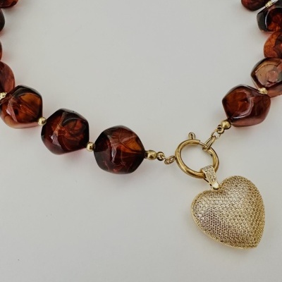 Colar com contas castanhas translúcidas e pendente dourado em forma de coração.