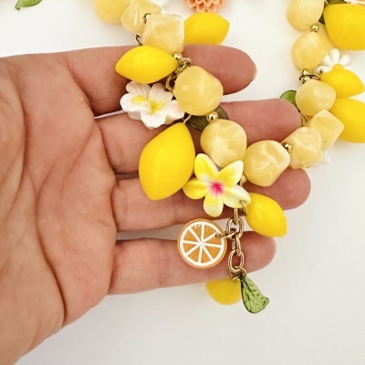 Colar com contas bege e elementos de limão amarelos, flores e pendentes coloridos