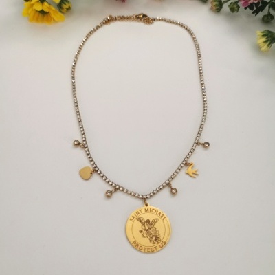 Colar dourado com pendentes e flores ao fundo