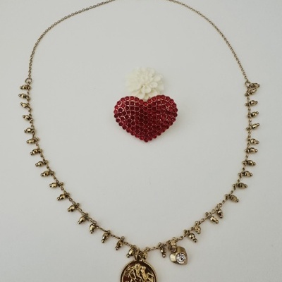 Colar dourado com pendentes variados e coração vermelho decorativo