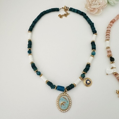 Colar com contas verdes e brancas, pingente oval com pássaro dourado e pérolas pequenas.