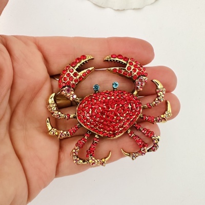 Broche caranguejo dourado com cristais vermelhos e azuis