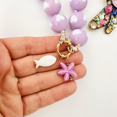 Pulseira com contas lilases e pingentes coloridos em forma de peixe e estrela do mar