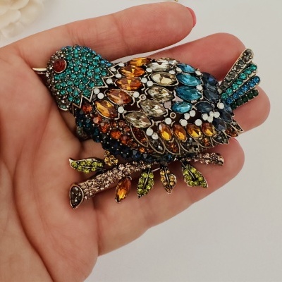 Broche de pássaro colorido com pedras em mão
