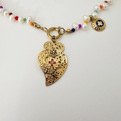 Colar com contas de pérolas e coloridas e pingente dourado decorado com cruz vermelha