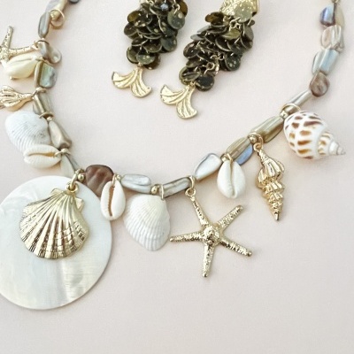 Colar e brincos com temas marinhos em conchas e metais dourados
