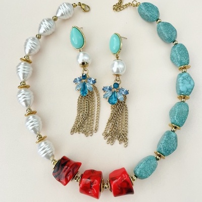 Colar com contas brancas, vermelhas e azul-turquesa e brincos com pedras azuis e franjas douradas