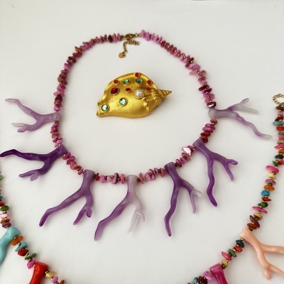 Colar de coral com peça central dourada e pedras coloridas