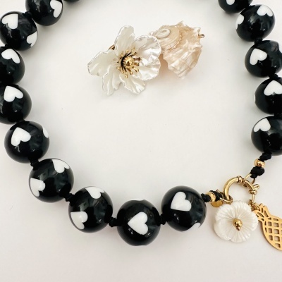 Colar preto com corações brancos, flor branca e concha natural com fecho dourado