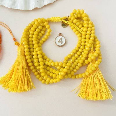 Colar de contas amarelas com tasséis e medalha número 4
