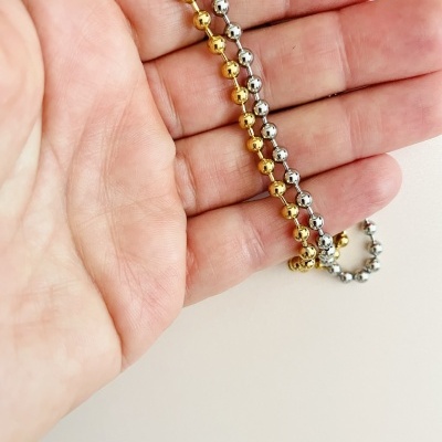 Colar em contas metálicas dourado e prateado na mão