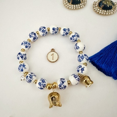 Pulseira com contas brancas e azuis com pendente dourado e conta com número 1