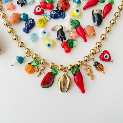Colar dourado com pendentes coloridos em forma de frutas, pimenta, insetos e conchas