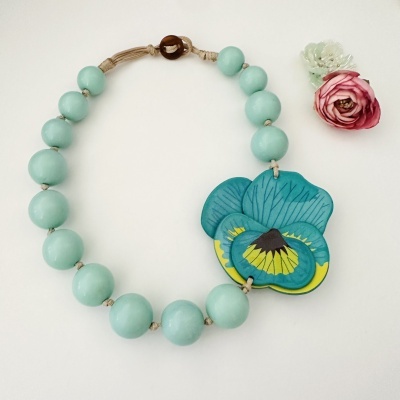 Colar de contas azuis com flor decorativa colorida e fecho de madeira