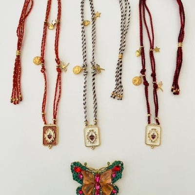 Três colares com pingentes de coração e um broche de borboleta colorida