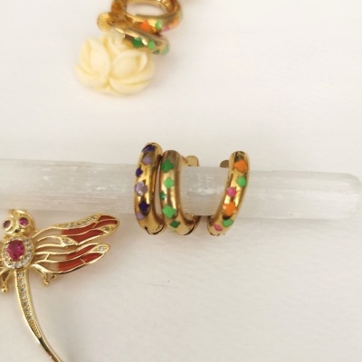 Conjunto de brincos dourados com esmalte colorido e pendente em forma de flor branca