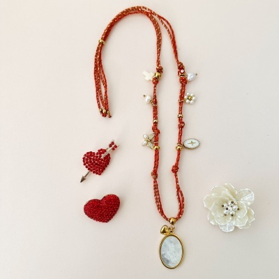 Colar vermelho com pendente oval branco, brincos coração vermelhos e flor branca decorativa com pérolas