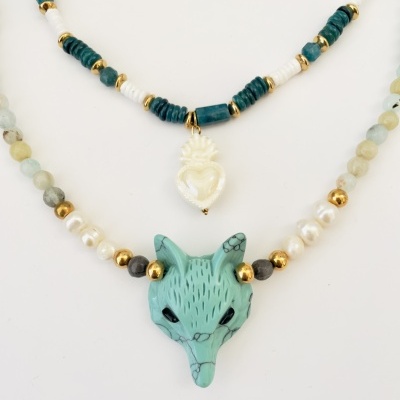 Conjunto de colares e brincos com pedras e cristais em fundo branco