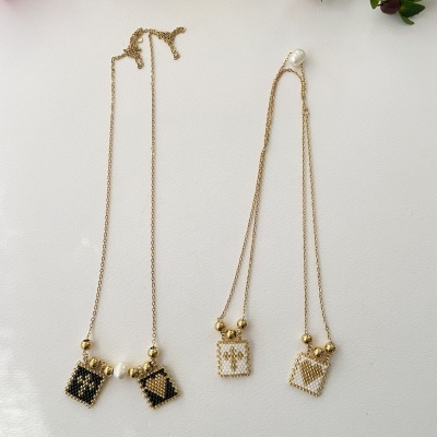 Quatro colares com pendentes quadrados de miçangas em várias cores sobre fundo branco com flores