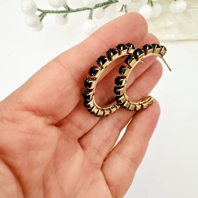 Brincos tipo argola dourados com pedras pretas e ramo decorativo