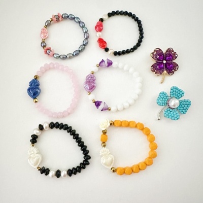 Pulseiras coloridas e broches de flores sobre fundo branco