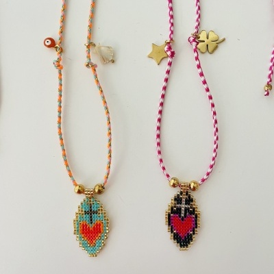 Duas pulseiras coloridas com pendentes em forma de coração feitas de contas pequenas brilhantes