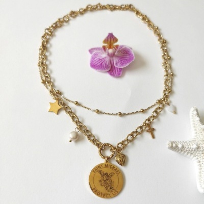 Colar dourado com pendentes e acessórios decorativos ao lado