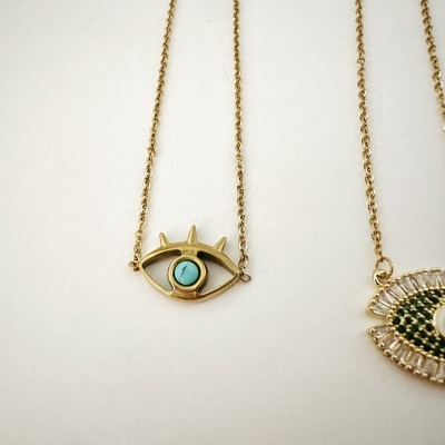 Colares dourados com pingentes em forma de olho com pedras coloridas