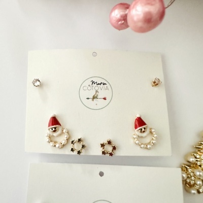 Conjunto de brincos com Pai Natal, laços de estrelas e pedras brilhantes em cartão de marca